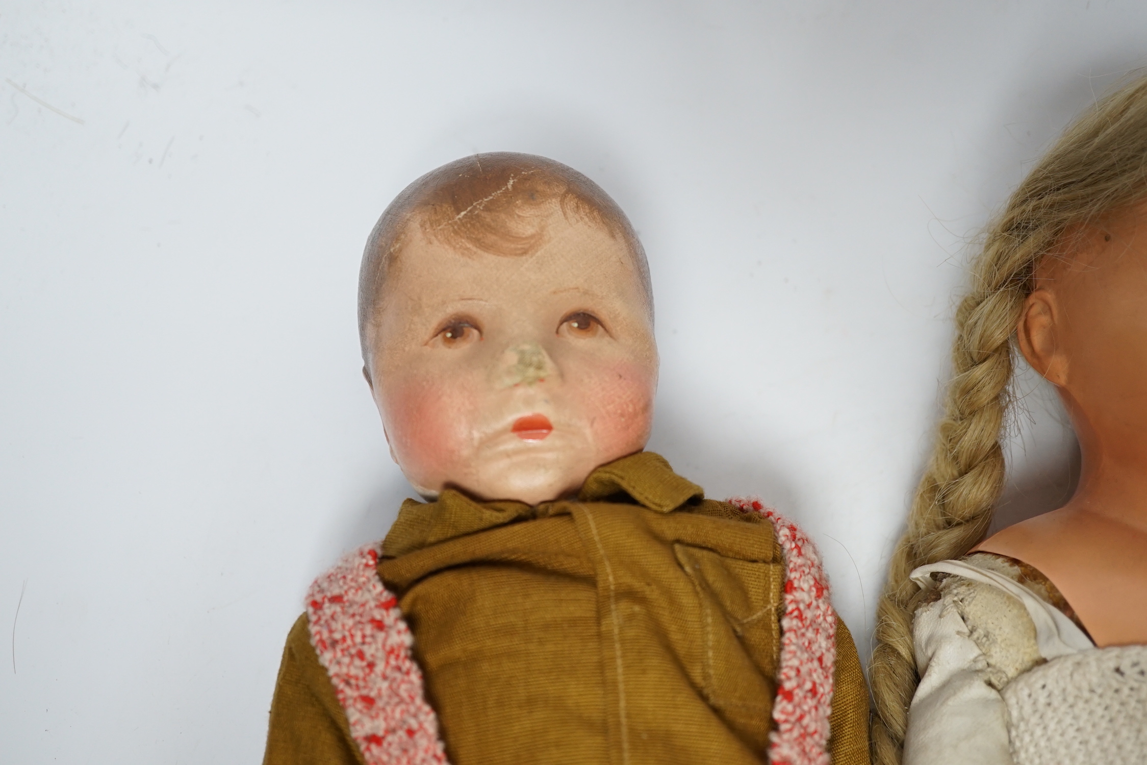 Three dolls including one by Kathe Kruse, original shirt, height 36cm, nose rubbed, one cloth doll, one celluloid with turtle mark eyes in head, height 46cm, original wig